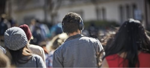 Homme marchant au milieu de la foule avec un casque sur les oreilles
