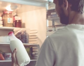 Photo d'un homme sortant du lait de son frigo