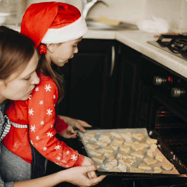Photo d'un mère aidant son enfant à mettre un plat dans un four