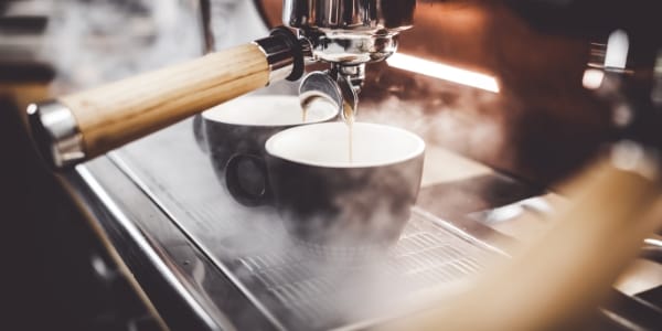 Photo de deux tasses à café en train d'être remplies de café