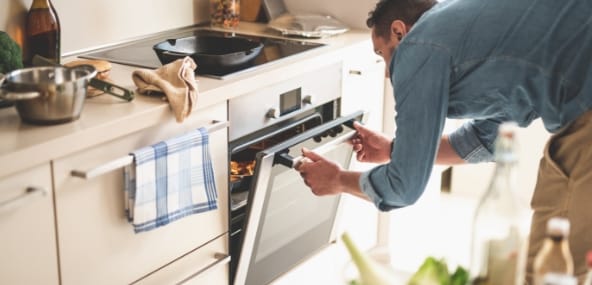 Photo d'un homme qui regarde dans son four