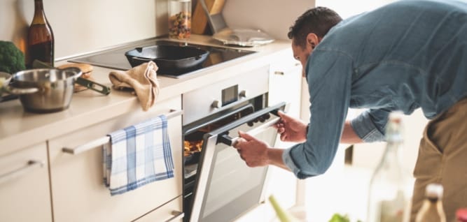 Photo d'un homme qui regarde dans son four