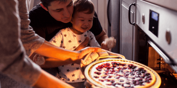 Photo d'un père et son fils devant un four