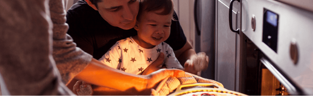Photo d'un père et son fils devant un four