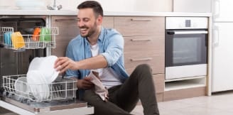 photo d'un homme étrangement trop heureux de vider son lave vaisselle